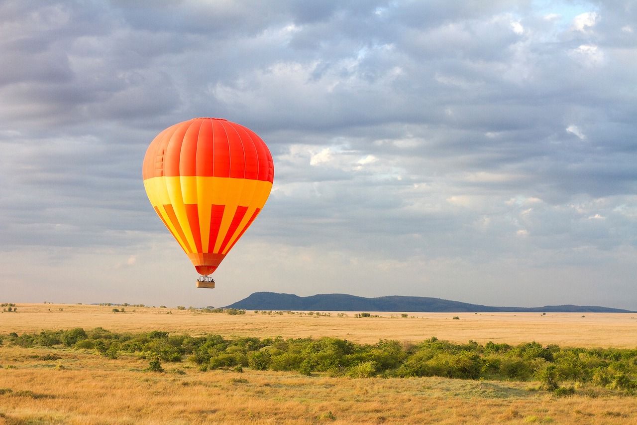 Orange hot air balloon above the Kenyan savannah